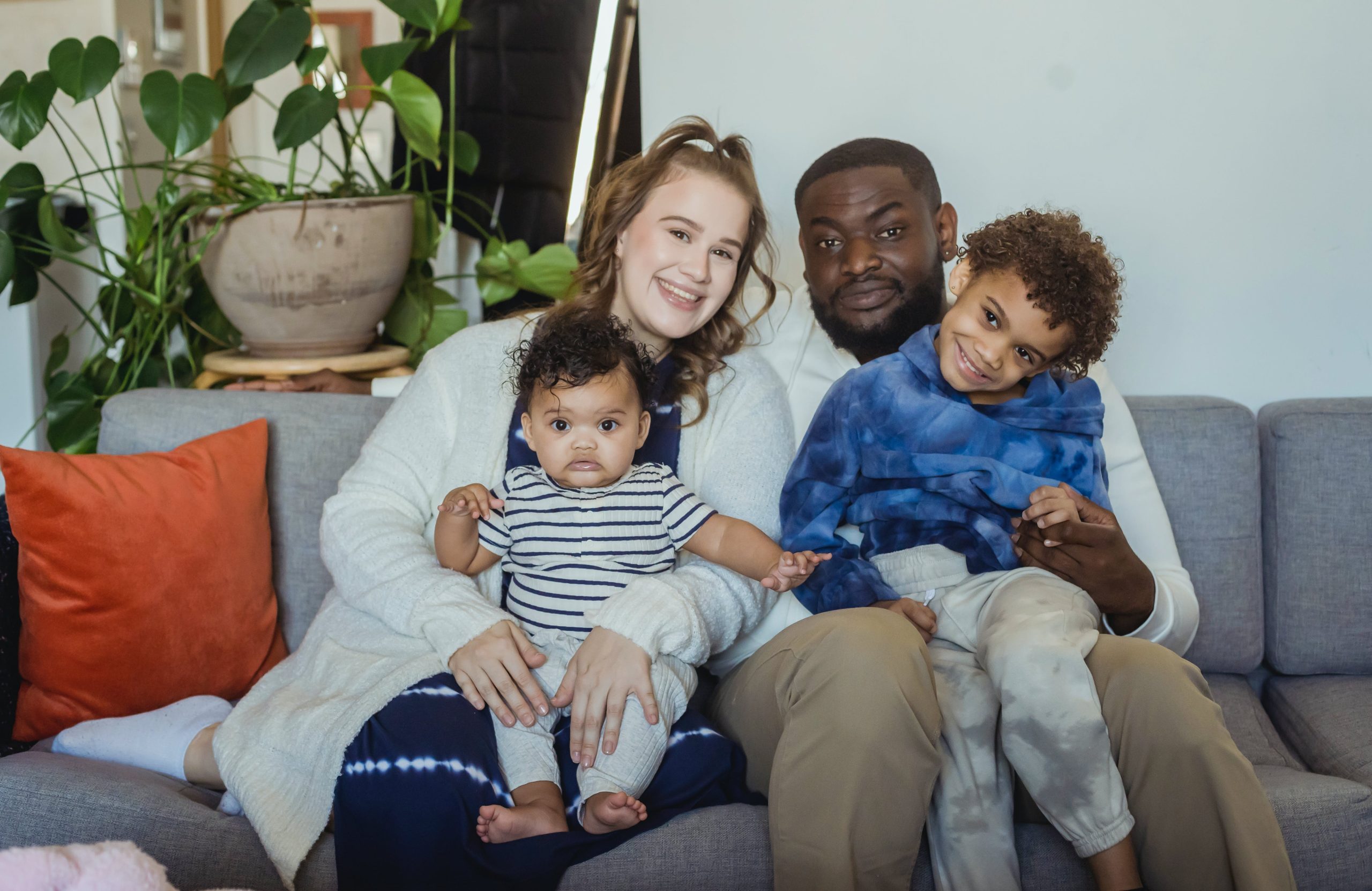 Multiracial couple in love hugging in a new home while holding keys in hands. Young multiracial family bought a new house, rent an apartment, got a mortgage